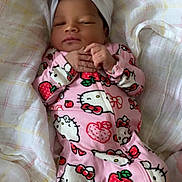 Stormi is registered to the contest to win money with this photo: baby, infant, child, sleeping, face, portrait, indoors, bed, blanket, pajamas, pink_clothing, headband, bow, hello_kitty, strawberry, plaid, lying_down, cozy, cute, home