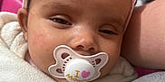 Eliana joined the competition — help win amazing prizes! baby, pacifier, headband, pink, sleepy, close_up, blanket, white, infant, person, face, resting, cute, soft_texture, cozy, child, young, wearing, comfort, indoor