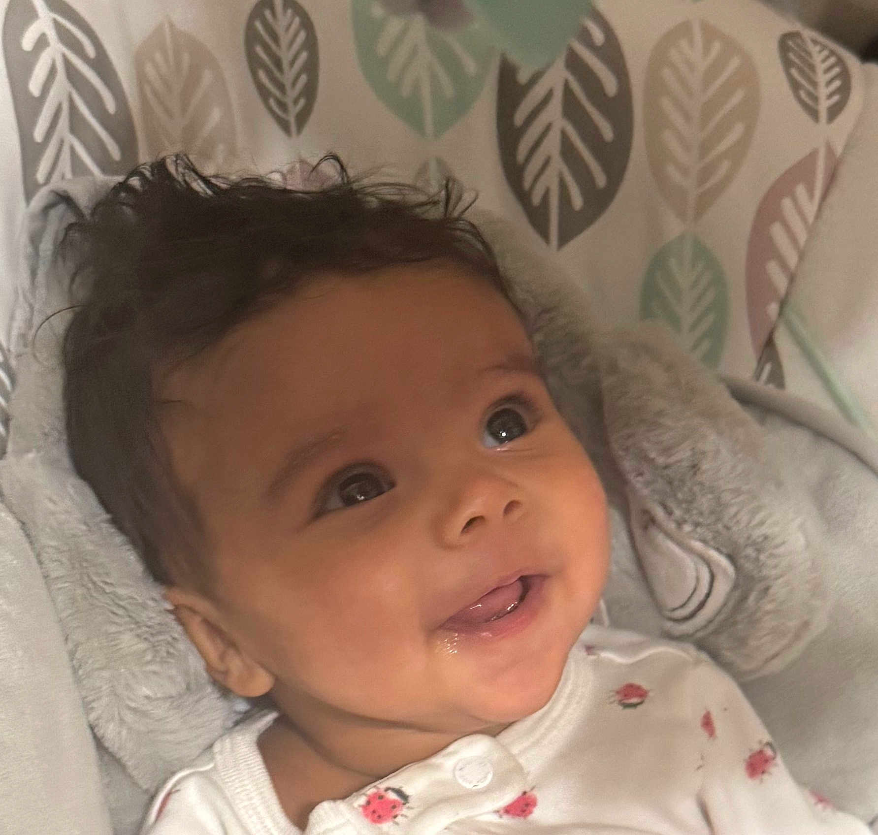 Eliana is registered to the contest to win money with this photo: baby, infant, face, smile, eyes, blanket, clothing, pattern, leaf, soft, cute, child, portrait, cozy, indoor, happy, young, head, skin, expression