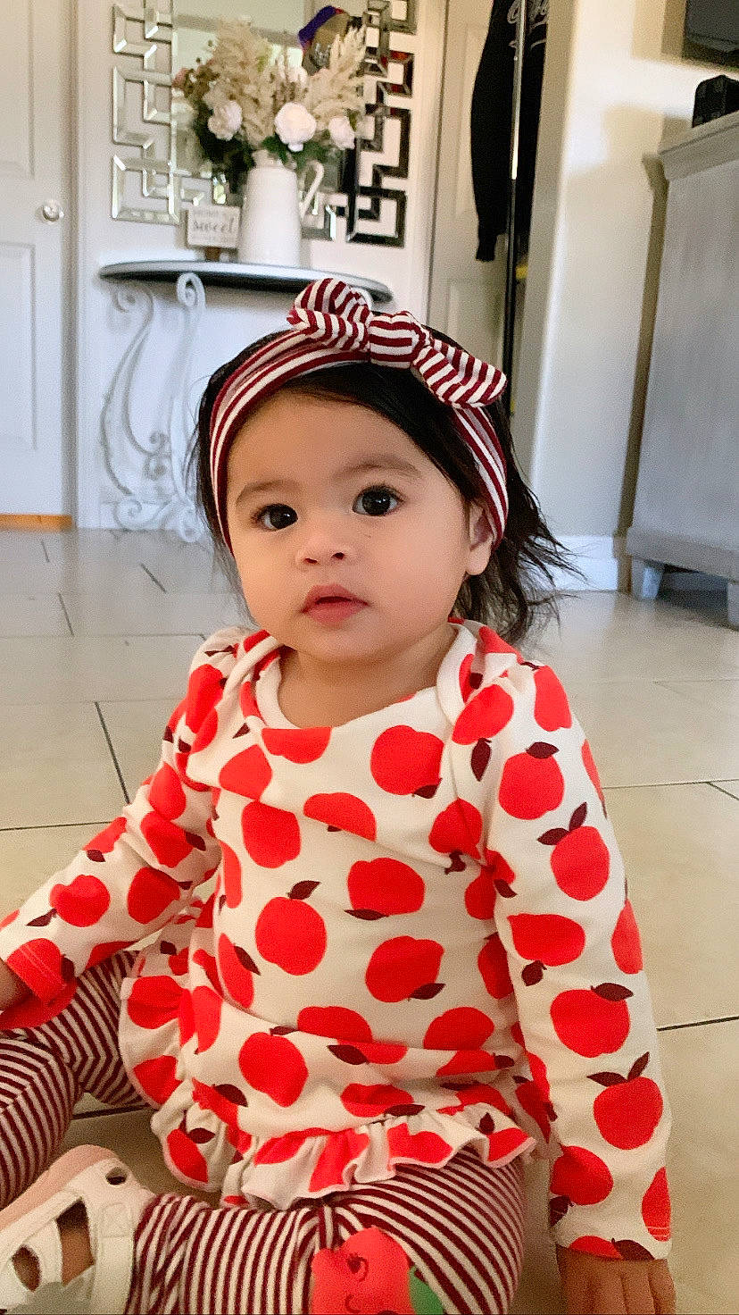 Coraline is registered to the contest to win money with this photo: baby, baby_toddler_clothing, cap, child, door, event, eye, flooring, fun, happy, hat, headwear, lip, pattern, person, pink, red, skin, sleeve, textile