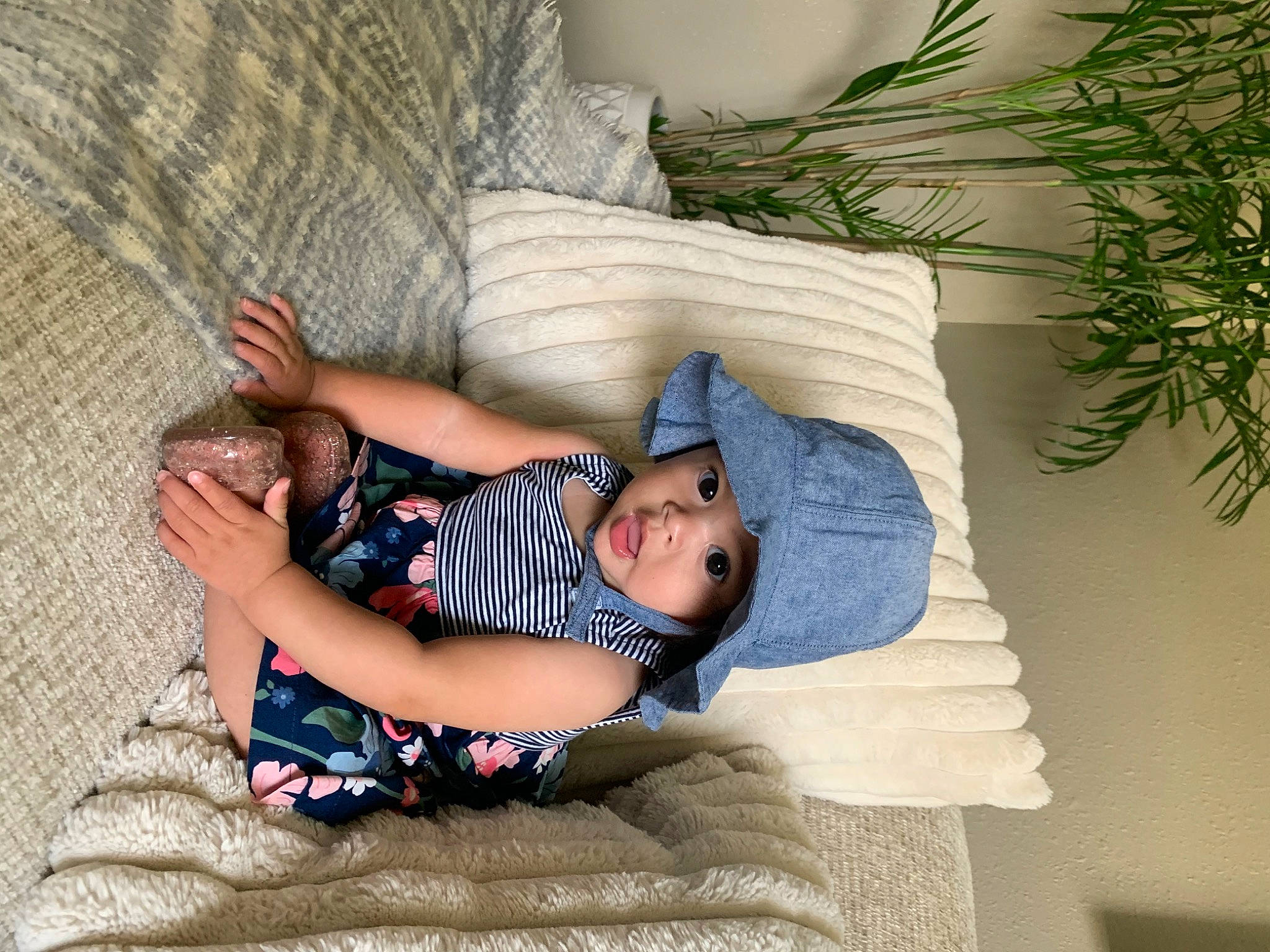 Coraline is registered to the contest to win money with this photo: baby, baby_toddler_clothing, child, comfort, electric_blue, foot, grass, headwear, human_leg, knee, lap, linens, pattern, person, room, sitting, sock, surprise, textile, thigh