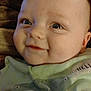 Liam is registered to the contest to win money with this photo: baby, blanket, cheeks, child, close_up, clothing, cute, eyes, face, green_shirt, happy, head, indoors, infant, person, portrait, skin, smiling, whale_design, young_child