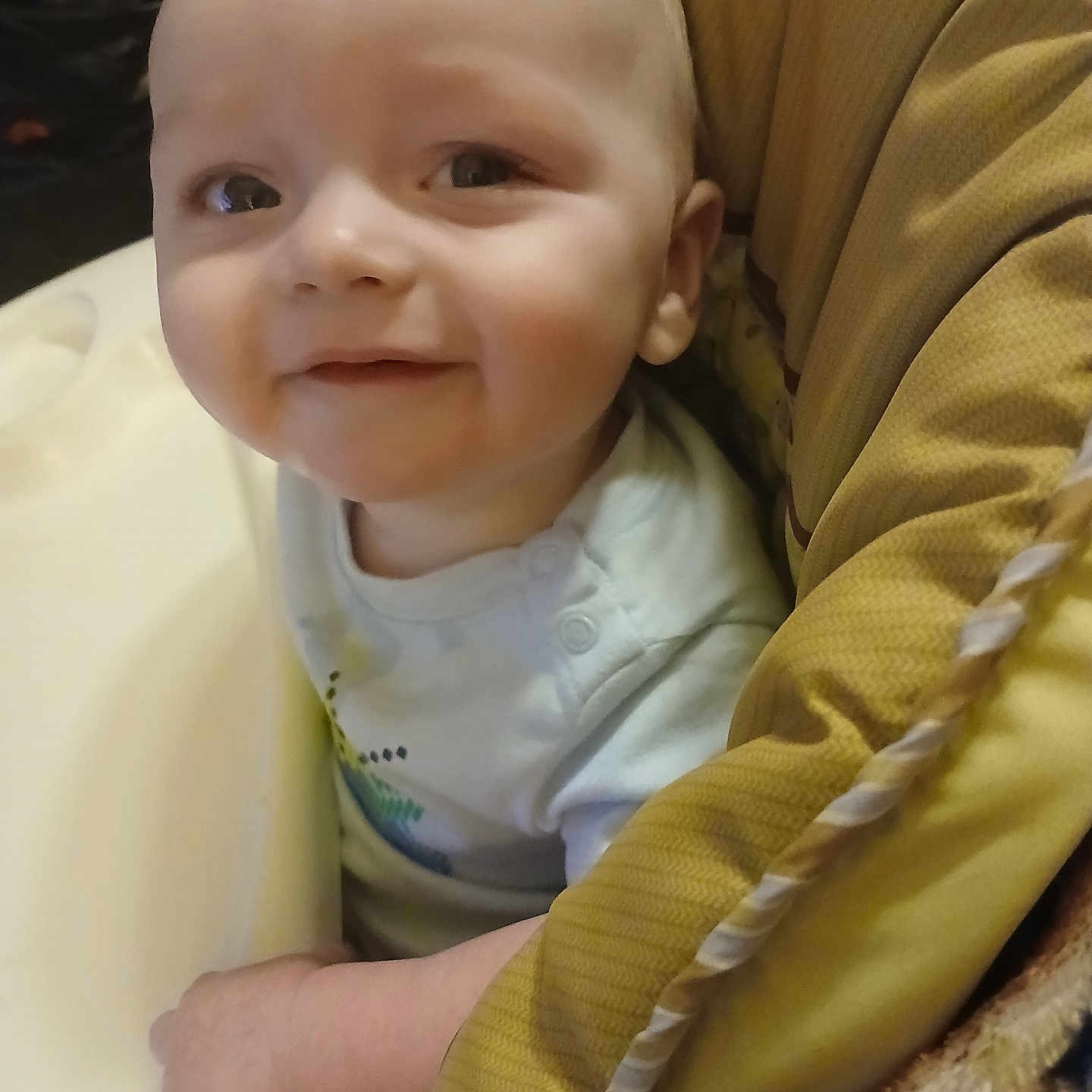 Liam joined the competition — help win amazing prizes! arm, baby, child, closeup, clothing, cushion, cute, face, happy, high_chair, indoor, infant, looking, person, portrait, seated, smile, soft_light, yellow, young_child