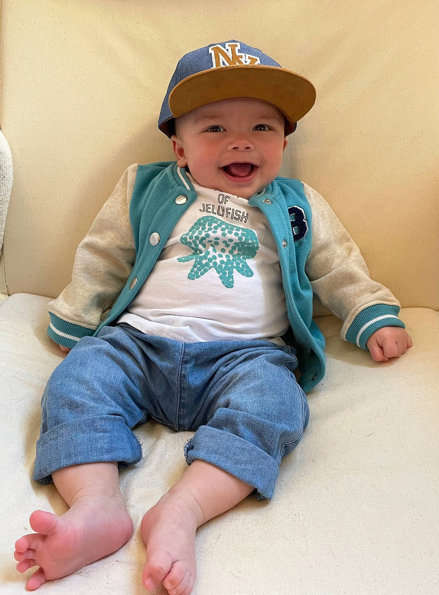 Jonas participe au concours pour gagner de l'argent avec cette photo : baby_toddler_clothing, barefoot, baseball_cap, cap, cheek, child, chin, comfort, denim, finger, foot, headwear, knee, leg, neck, person, skin, sleeve, t_shirt, thigh