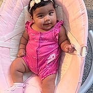 Eliana is registered to the contest to win money with this photo: baby, child, infant, smiling, happy, portrait, pink, bouncer, baby_seat, flower_headband, romper, shoes, socks, indoors, carpet, seated, lying_down, cute, fashion, photography