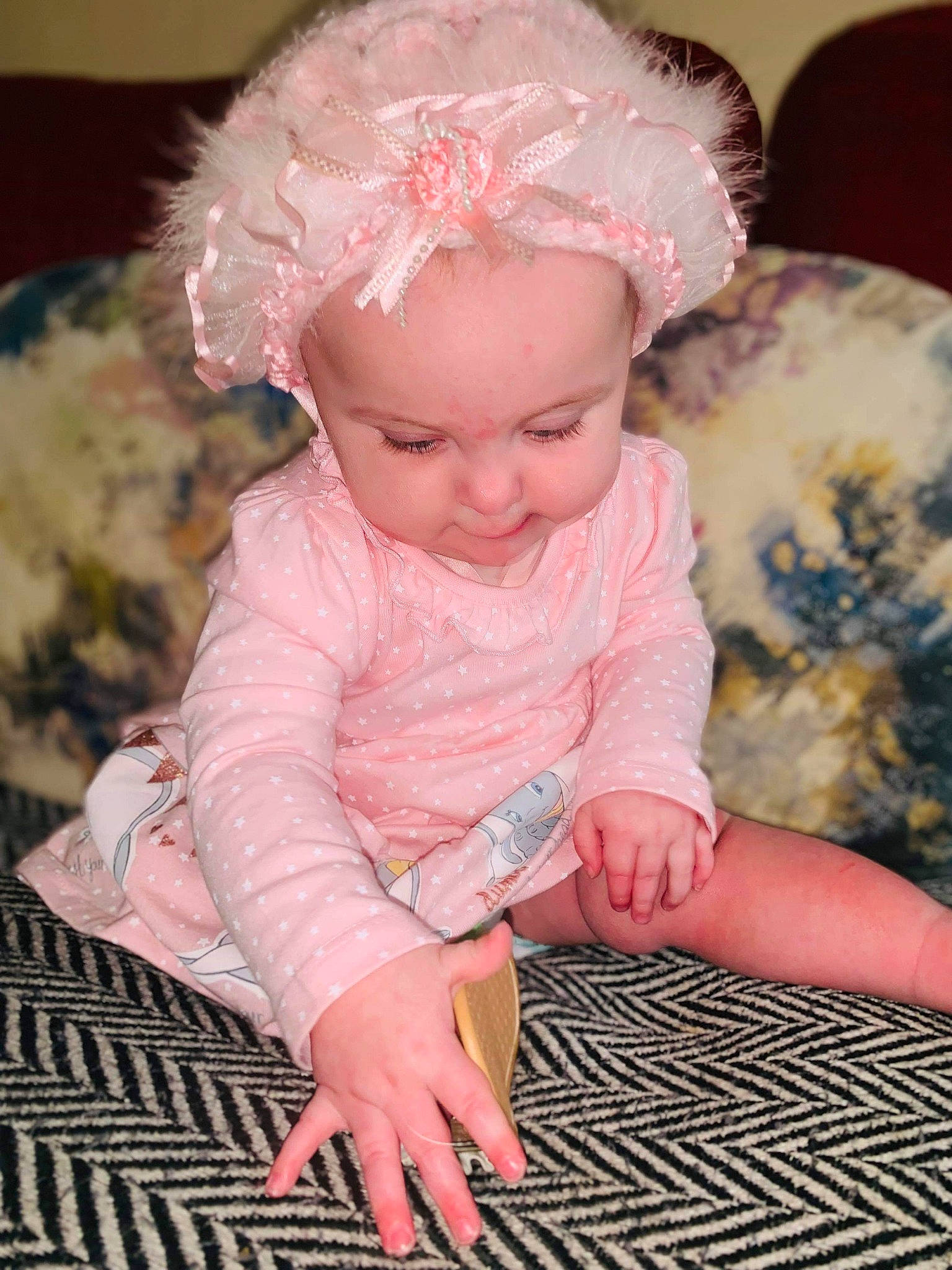 Lola is registered to the contest to win money with this photo: baby, baby_toddler_clothing, cheek, child, hair_accessory, head, headgear, person, pink, play, sitting, toddler