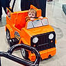 toddler, child, toy_car, orange, indoor, floor, person, hands, steering_wheel, plastic, vehicle, playing, curious, small, young_child, footwear, reflection, people, casual_clothing, shopping_area