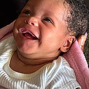 Jahmaika joined the competition — help win amazing prizes! baby, blanket, child, close_up, cozy, curly_hair, cute, ear, expression, face, hand, happy, indoors, infant, newborn, person, portrait, skin, smile, white_clothing