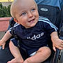 Reuben is registered to the contest to win money with this photo: baby, child, stroller, blue_eyes, smiling, adidas, clothing, footwear, barefoot, outdoor, sunlight, happy, infant, cute, person, seat, sitting, hand, face, portrait
