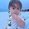 toddler, child, beach, ocean, sand, blue_eyes, wet_hair, white_shirt, floral_pattern, portrait, outdoor, twilight, curious, person, holding, hand, nature, sky, vacation, cute