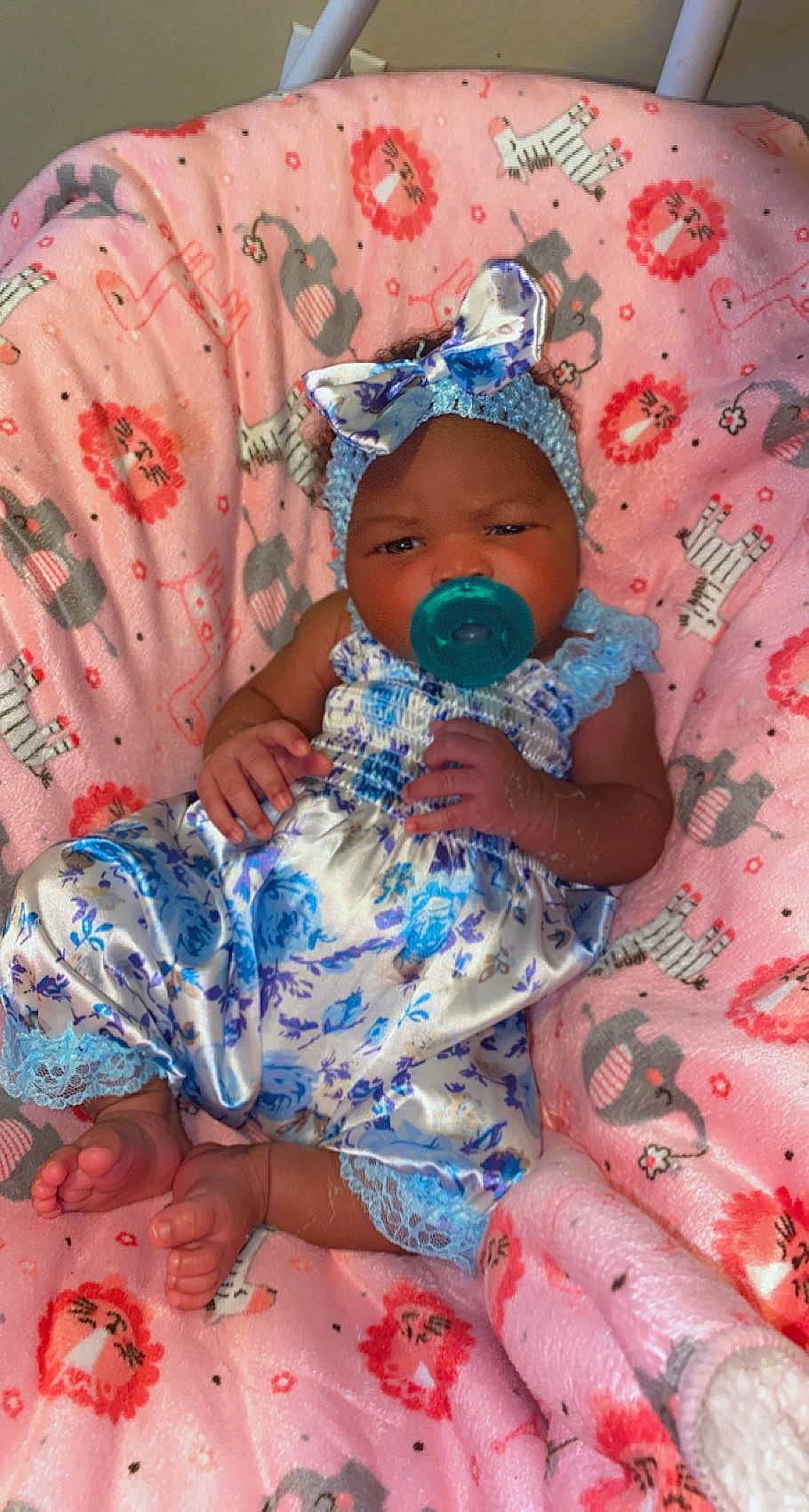 Imani is registered to the contest to win money with this photo: arm, baby, baby_products, baby_sleeping, baby_toddler_clothing, cap, cheek, child, comfort, fun, hat, headgear, headwear, pattern, person, pink, red, sitting, skin, sleeve