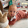 baby, infant, toy, bunny, wooden_toy, play_mat, crib, nursery, child, indoor, floor, clothing, person, cute, blue_eyes, soft_toy, play, furniture, expression, toddler