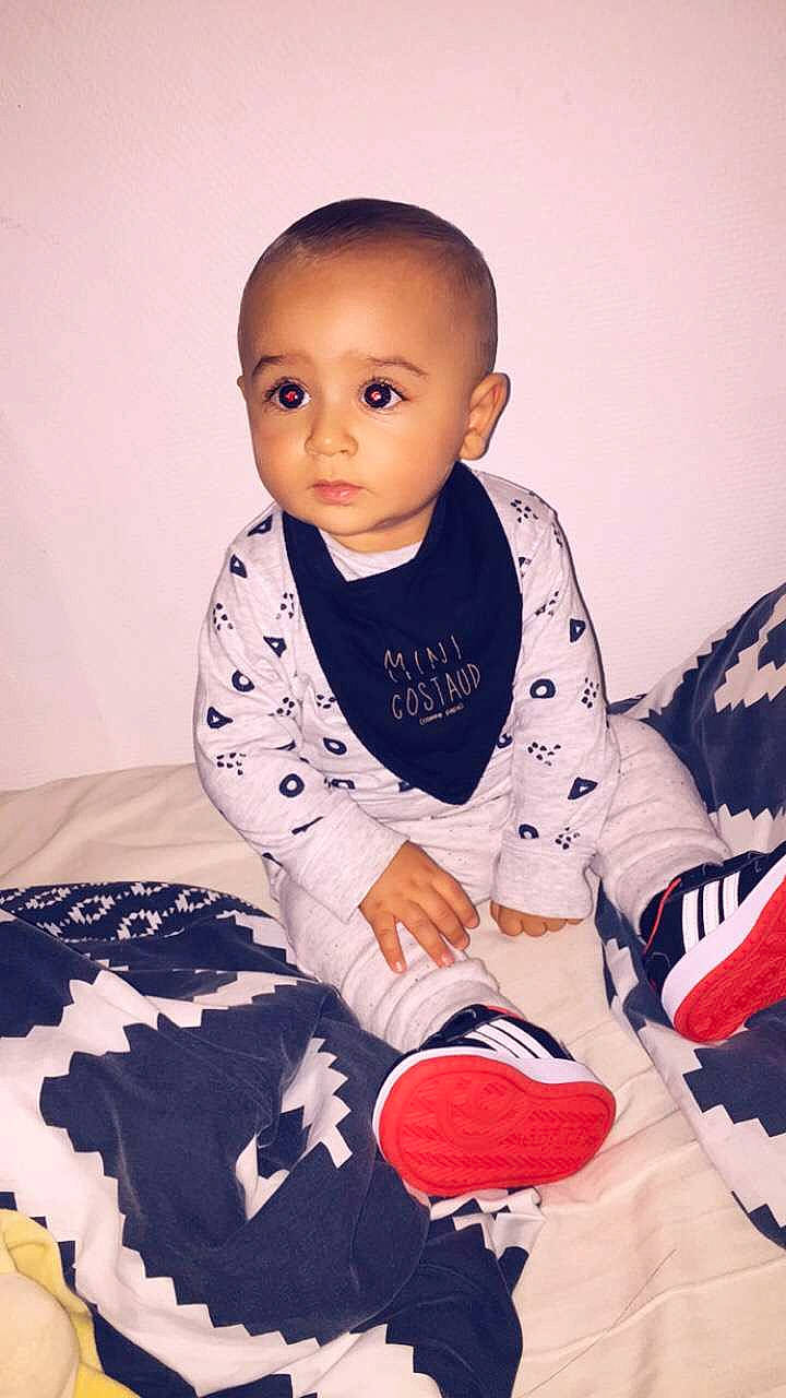 Zyad participe au concours pour gagner de l'argent avec cette photo : arm, baby, baby_toddler_clothing, cheek, child, outerwear, pajamas, person, play, shoe, sitting, skin, sleeve, t_shirt, toddler