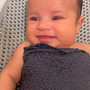 Jaelani is registered to the contest to win money with this photo: baby, smiling, towel, wet_skin, face, blue_eyes, infant, closeup, portrait, skin, head, child, happy, expression, arm, person, background, water_drops, newborn, indoors