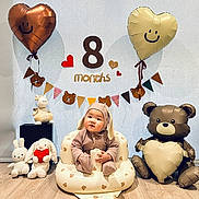 Desmond joined the competition — help win amazing prizes! baby, infant, bunny_outfit, plush_toys, inflatable_chair, balloons, heart_balloon, bear_balloon, wooden_floor, banner, milestone, smile, cute, celebration, indoor, child, toy, decorations, happy, person