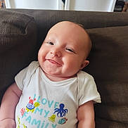 Eden a rejoint le concours — aidez-le/la à gagner de superbes lots ! baby, infant, smiling, couch, white_onesie, text_on_clothing, sea_creatures, turtle, whale, octopus, fish, crab, happy, cheeky, cute, child, indoors, portrait, relaxed, family