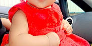Myra joined the competition — help win amazing prizes! baby, child, red_dress, car_interior, person, infant, cute, sitting, curious, face, arm, hand, leg, window, seat, clothing, portrait, skin, head, young