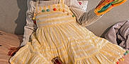 Layla joined the competition — help win amazing prizes! toddler, child, yellow_dress, pom_poms, blue_bow, toy, rainbow_colored, white_tights, unicorn_blanket, bed, smiling, happy, indoor, playtime, cute, sitting, person, face, clothing, hair_bow