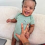 Aireon joined the competition — help win amazing prizes! baby, child, smiling, laughing, onesie, green_clothing, tattoo, bracelet, hand, couch, blanket, laptop, indoor, happy, person, infant, sitting, white_socks, skin, portrait
