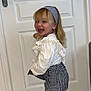 accessory, blonde_hair, checkered_skirt, child, cute, door, fashion, footwear, girl, happy, headband, indoor, playful, portrait, smiling, standing, tights, tile_floor, white_blouse, young