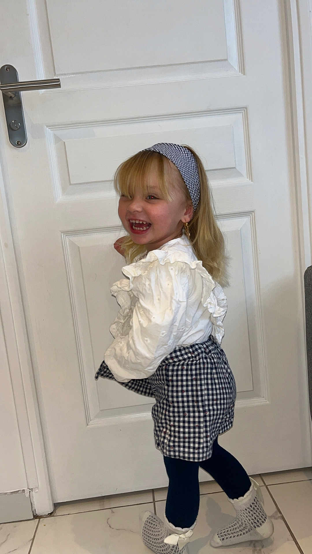 Maivy a rejoint le concours — aidez-le/la à gagner de superbes lots ! accessory, blonde_hair, checkered_skirt, child, cute, door, fashion, footwear, girl, happy, headband, indoor, playful, portrait, smiling, standing, tights, tile_floor, white_blouse, young