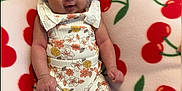 Amyra joined the competition — help win amazing prizes! baby, infant, bow, headwear, floral_outfit, blanket, cherry_pattern, smile, cute, child, clothing, sitting, face, hands, feet, indoors, soft_texture, colorful, portrait, young
