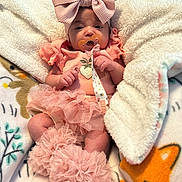 Amyra is registered to the contest to win money with this photo: baby, infant, pink_clothing, headband, bow, pacifier, blanket, ruffles, soft_toys, cute, cozy, sleepwear, child, newborn, tutu, plush, comfort, indoors, resting, adorable