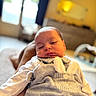 Irakli participe au concours pour gagner de l'argent avec cette photo : baby, sleeping, infant, cozy, outfit, bunny_ears, pocket, person, legs, indoor, blurred_background, warm_lighting, soft_focus, peaceful, cute, child, newborn, portrait, resting, casual