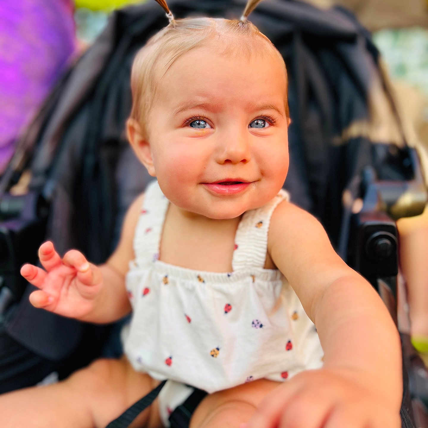 Merrin joined the competition — help win amazing prizes! baby, child, closeup, clothing, cute, daylight, expression, face, happy, infant, outdoor, person, pigtails, portrait, reaching, seatbelt, skin, smiling, stroller, summer