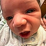 Benito is registered to the contest to win money with this photo: baby, newborn, face, close-up, expression, infant, skin, clothing, onesie, indoor, person, portrait, cute, child, young, human, small, head, eyes, mouth