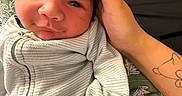 Benito joined the competition — help win amazing prizes! baby, infant, onesie, hand, tattoo, face, expression, close_up, portrait, sleepwear, skin, person, cute, cozy, resting, bed, blanket, indoor, comfort, newborn