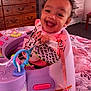 Rosalia is registered to the contest to win money with this photo: activity_seat, baby, bedspread, butterfly_sticker, child, curly_hair, dresser, furniture, happy, heart_sticker, indoor, mirror, person, photo_frame, pink, playful, purple, room, smiling, toy