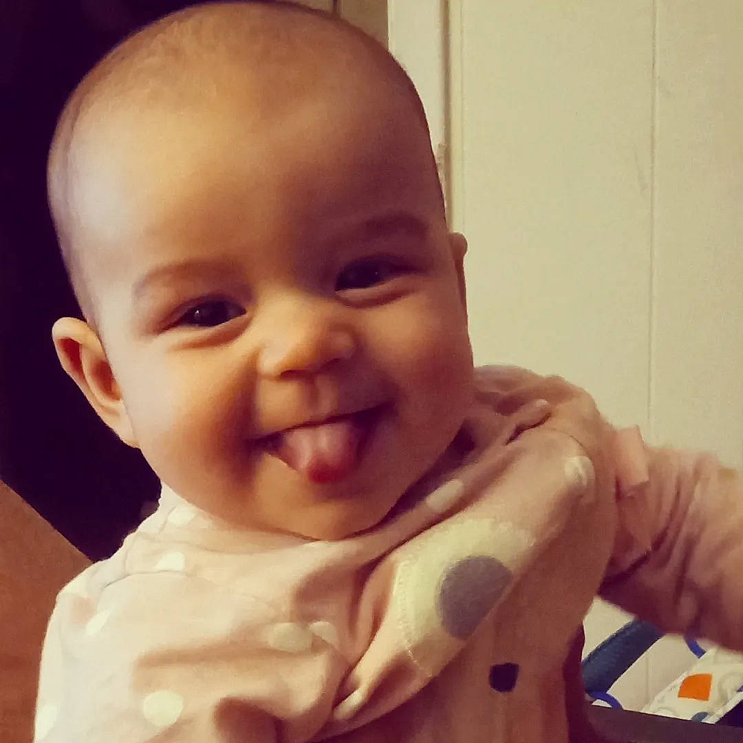 Jade is registered to the contest to win money with this photo: arm, baby_toddler_clothing, cheek, ear, eye, eyebrow, finger, forehead, gesture, happy, human_body, iris, jaw, joy, lip, mouth, nose, person, skin, sleeve