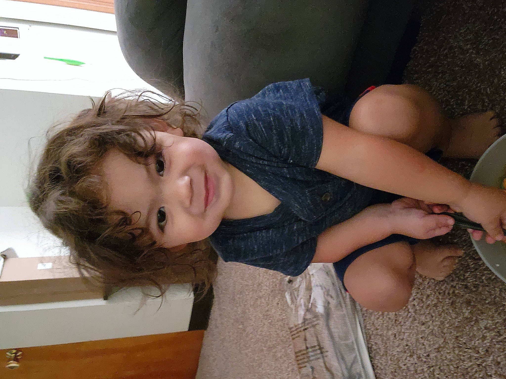 Malaki is registered to the contest to win money with this photo: abdomen, chest, child, comfort, elbow, eye, eyelash, face, fun, happy, human_leg, joint, long_hair, person, sitting, skin, smile, tableware, thigh, toddler