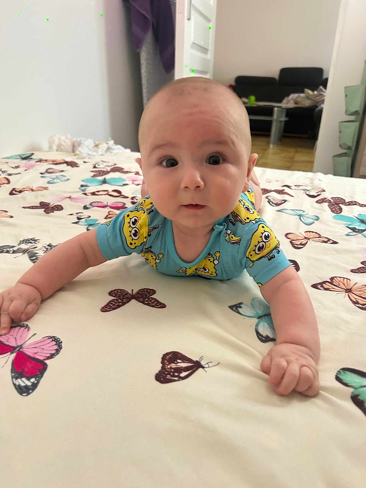Matia participe au concours pour gagner de l'argent avec cette photo : baby, bed, bedspread, blue_clothing, butterfly_pattern, child, crawling, curious, expression, eyes, face, floor, furniture, hands, indoor, infant, person, portrait, skin, spongebob