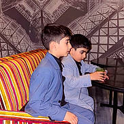 Hadi Et Talib a rejoint le concours — aidez-le/la à gagner de superbes lots ! child, boys, suits, striped_couch, indoor, table, drink, portrait, seated, side_view, wall_mural, geometric_pattern, young, fashion, casual, concentration, furniture, colorful, people, friends