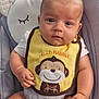 Côme a rejoint le concours — aidez-le/la à gagner de superbes lots ! baby, infant, bib, yellow_bib, monkey_design, baby_seat, cushion, cute, child, portrait, indoor, clothing, hand, face, expression, young_child, seated, soft_toys, smile, looking_at_camera