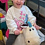 Payton is registered to the contest to win money with this photo: baby, bodypart, clothing, electronics, face, finger, footwear, furniture, hand, happy, head, pants, person, phone, photography, portrait, shoe, sitting, smile, wood