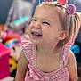 toddler, child, smiling, happy, pink_dress, headband, indoor, portrait, cute, playful, face, young_child, blonde_hair, expression, toy, colorful_background, cheerful, person, closeup, baby
