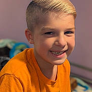 Oliver is registered to the contest to win money with this photo: child, boy, smiling, portrait, orange_shirt, blonde_hair, short_hair, happy, indoors, face, casual_clothing, youth, cute, person, human, closeup, tshirt, expression, cheerful, young