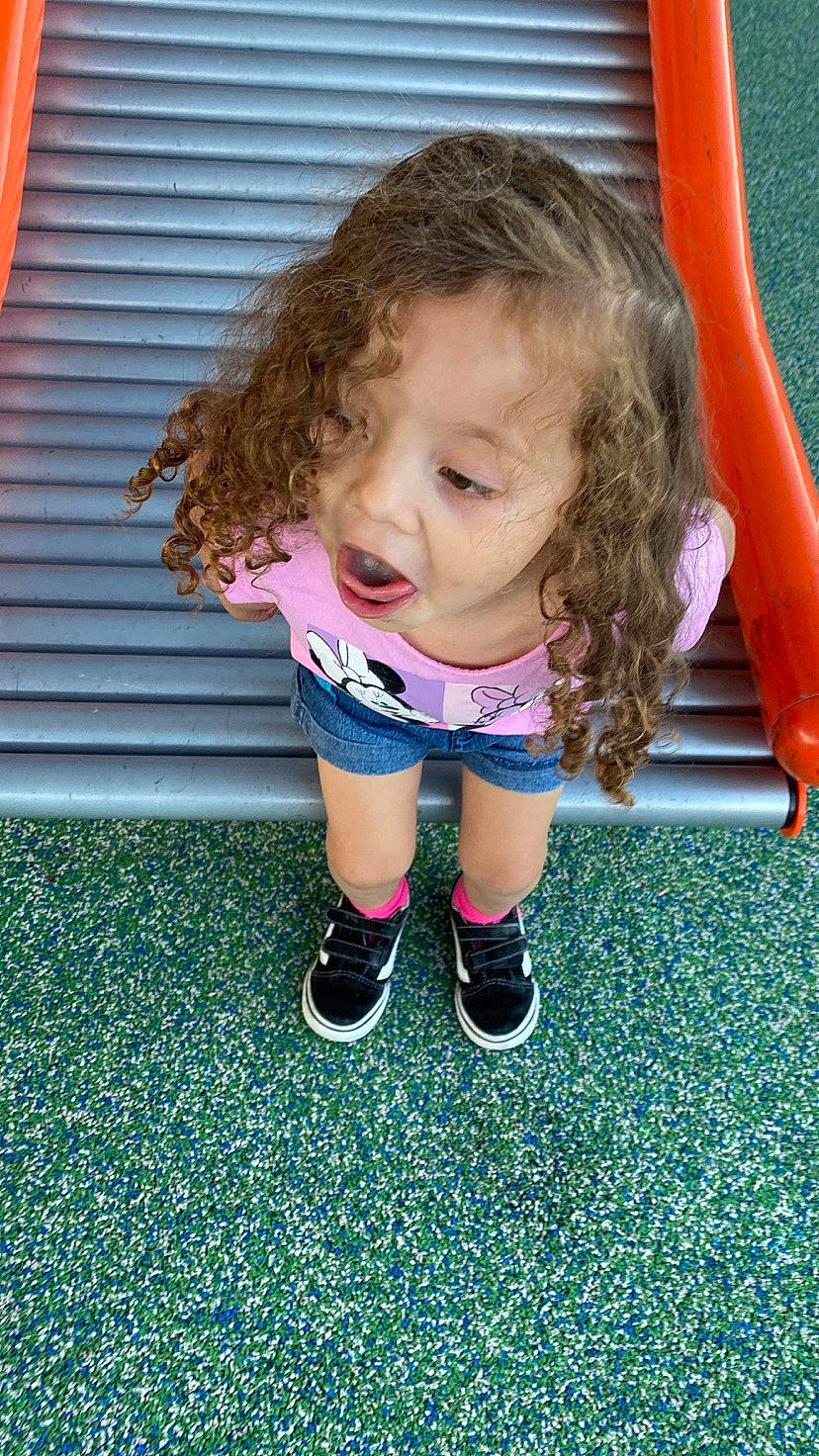 Alanna joined the competition — help win amazing prizes! baby_toddler_clothing, blond, child, electric_blue, flooring, foot, fun, grass, human_leg, knee, leg, leisure, magenta, outdoor_play_equipment, person, playground, recreation, sock, t_shirt, thigh