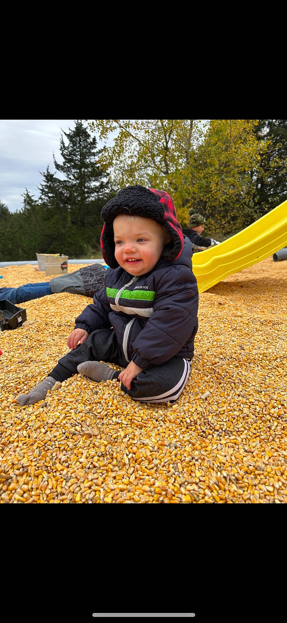 Denver is registered to the contest to win money with this photo: baby, child, deciduous, fun, grass, happy, hat, headwear, landscape, leisure, people_in_nature, person, plant, public_space, recreation, sky, smile, soil, sunlight, toddler