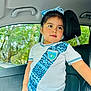 blue_bow, car_interior, car_seat, casual, child, clothing, cute, daylight, expression, girl, guatemala, headwear, person, portrait, short_sleeves, soccer_jersey, standing, trees, window, young