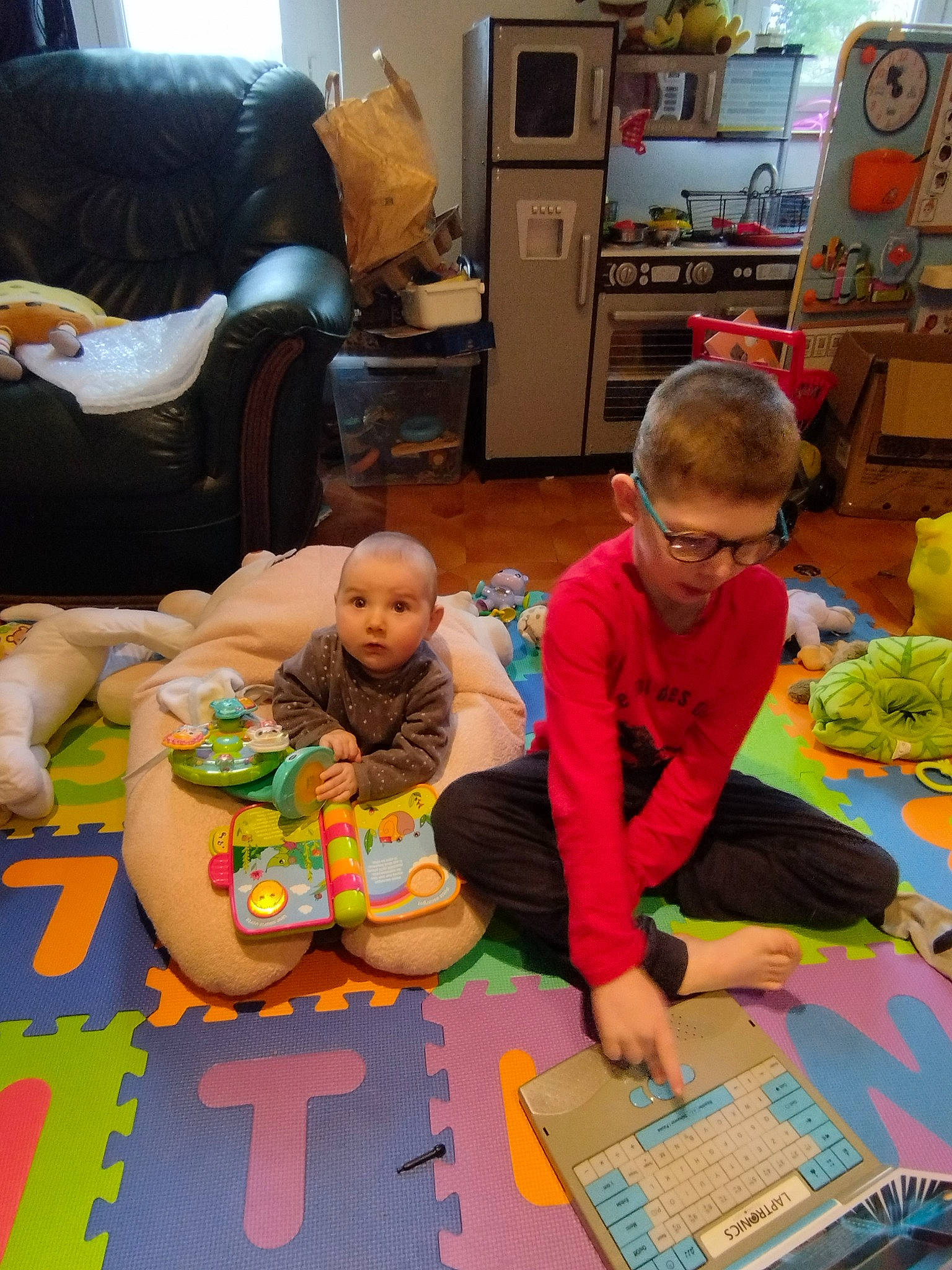 Björn participe au concours pour gagner de l'argent avec cette photo : art, baby, chair, child, event, flooring, fun, kindergarten, leisure, living_room, person, play, room, sharing, shelf, sitting, t_shirt, television, toddler, toy