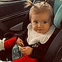 Sawyer is registered to the contest to win money with this photo: toddler, child, car_seat, pigtails, snack, red_pants, white_shoes, bib, car_interior, window, seatbelt, bottle, curious_expression, baby, young_child, clothing, person, sitting, indoors, transportation