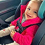 toddler, child, car_seat, pink_jacket, smiling, snack, car_interior, seatbelt, window, hair, cute, happy, clothing, sitting, young_child, baby, face, person, warm_clothes, cozy