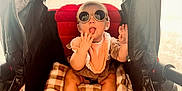 Sawyer is registered to the contest to win money with this photo: baby, child, stroller, sunglasses, blanket, bib, cute, playful, tongue, infant, seated, canopy, red, brown, checkered, clothing, foot, hand, indoor, portrait