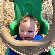Jaylen is registered to the contest to win money with this photo: baby, beige, blue_clothing, child, daylight, fun, green, hands, happy, outdoor, play, playcore, playground, seat, smiling, sunlight, swing, toddler, woodchips, young_child