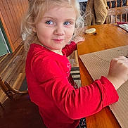 June joined the competition — help win amazing prizes! child, blonde_hair, blue_eyes, red_shirt, candy_cane_pants, wooden_table, wooden_chair, cookie, indoor, smiling, playing, cozy, holiday_theme, long_sleeve, person, table, chair, floor, window, home