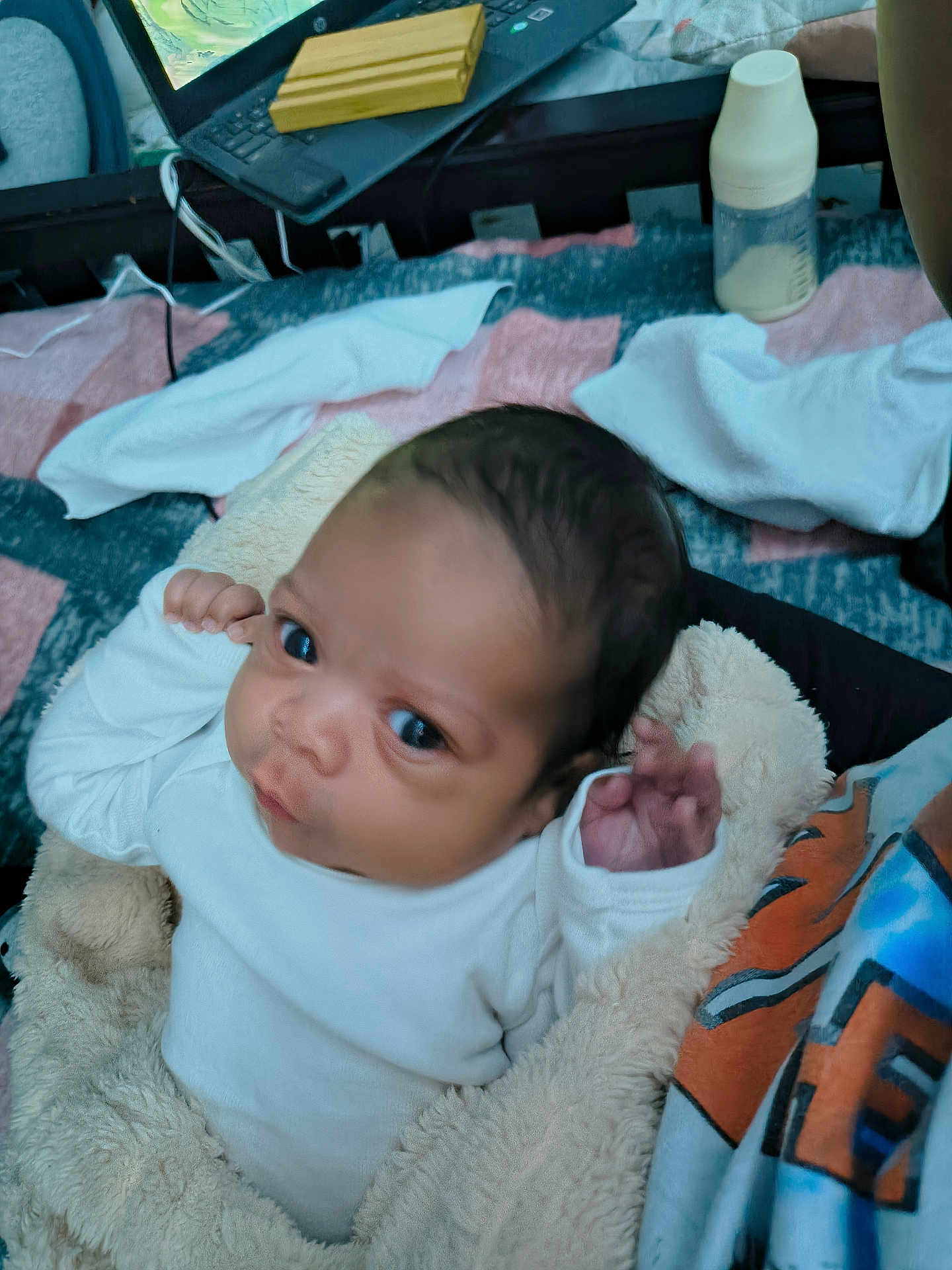 James is registered to the contest to win money with this photo: baby, blanket, infant, bottle, clothing, person, face, hand, indoor, soft_texture, curious, cute, newborn, wrapped, toddler, close_up, portrait, warm, resting, care